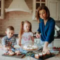 Anak-anak sedang menikmati ide kegiatan memasak bersama anak di meja dapur rumah
