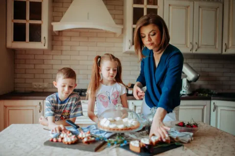 Anak-anak sedang menikmati ide kegiatan memasak bersama anak di meja dapur rumah