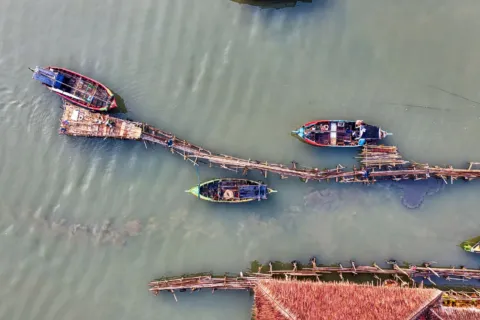 Suasana dermaga dan kayu perahu tradisional dalam kegiatan wisata perkampungan nelayan