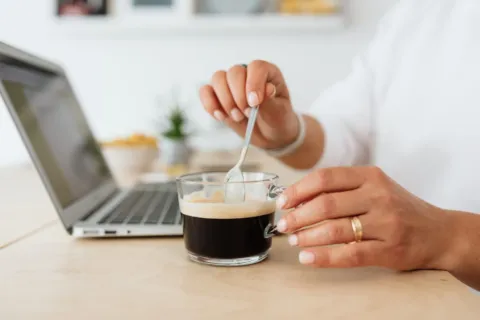 Suasana meja kerja hangat dengan secangkir kopi untuk membangun kebiasaan pagi produktif