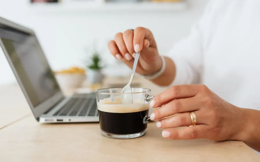 Suasana meja kerja hangat dengan secangkir kopi untuk membangun kebiasaan pagi produktif